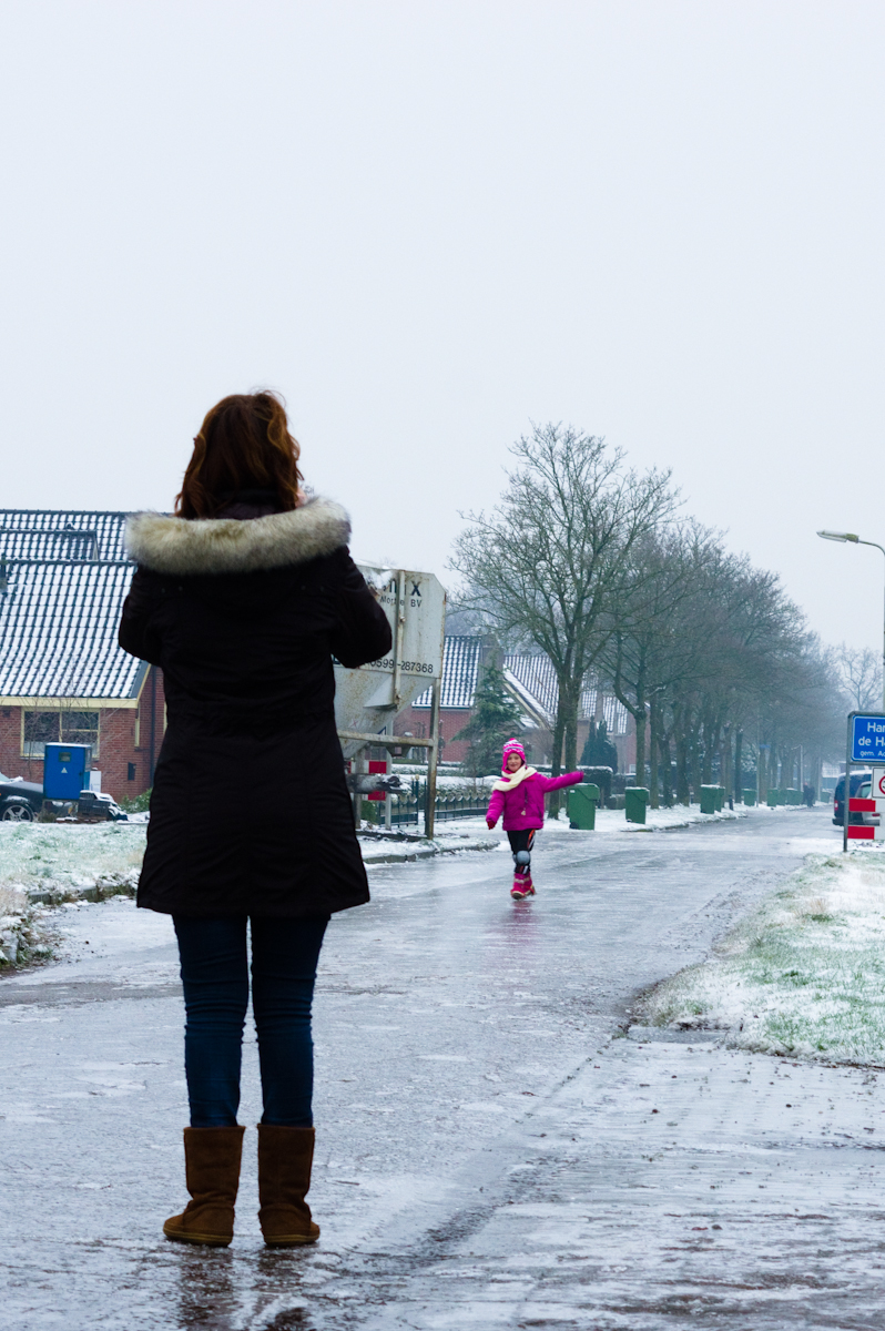 roze gekleed meisje schaats op de straten van harkema, gefotografeerd door haar moeder en door jeffrey wakanno. De ijzel hield het noorden van nederland in zijn ijzige greep.